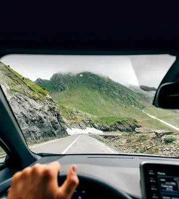 looking out the front of a car driving in the mountains