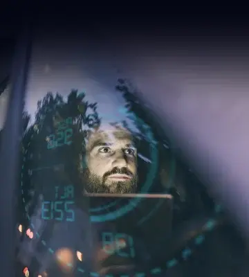 Man's face reflected in the electronic dashboard HUD.