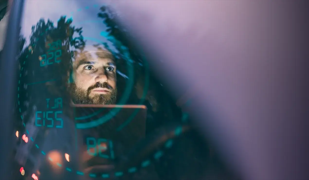 Man's face reflected in the electronic dashboard HUD.