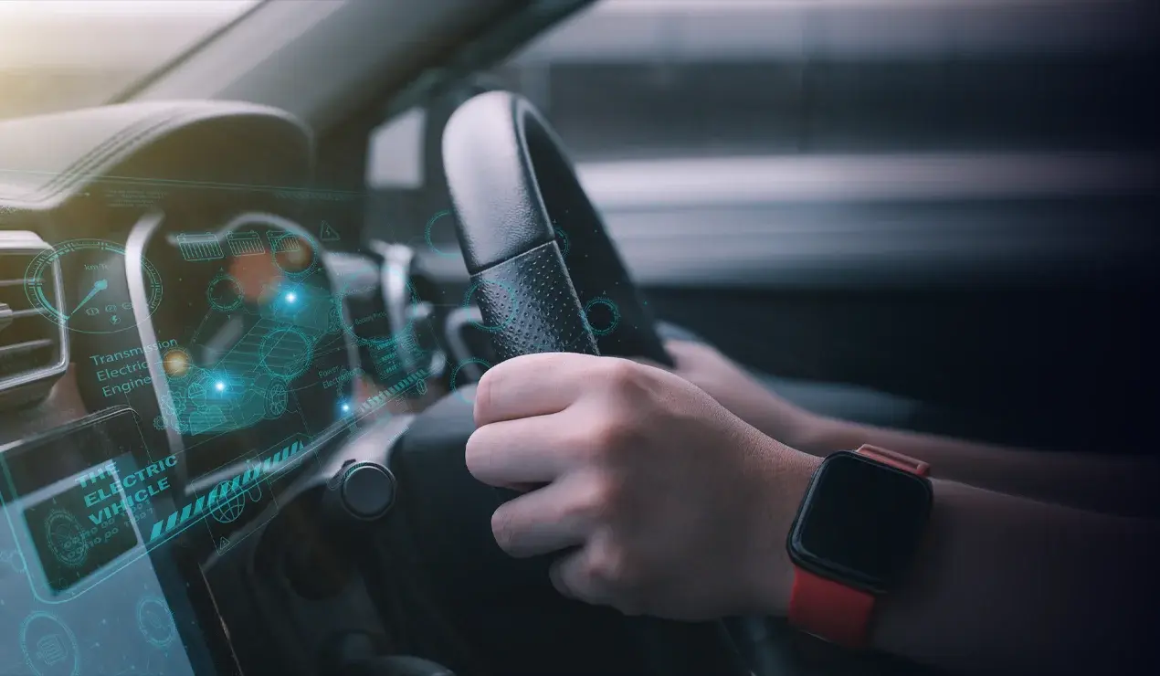 Hands on steering wheel with an electronic overlay on the dashboard.